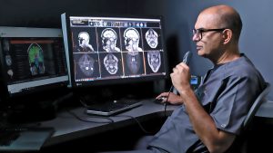 Sunshine Coast Radiology Warana Radiologist looking at test results about to speak into a microphone to communicate with the patient in the MRI machine